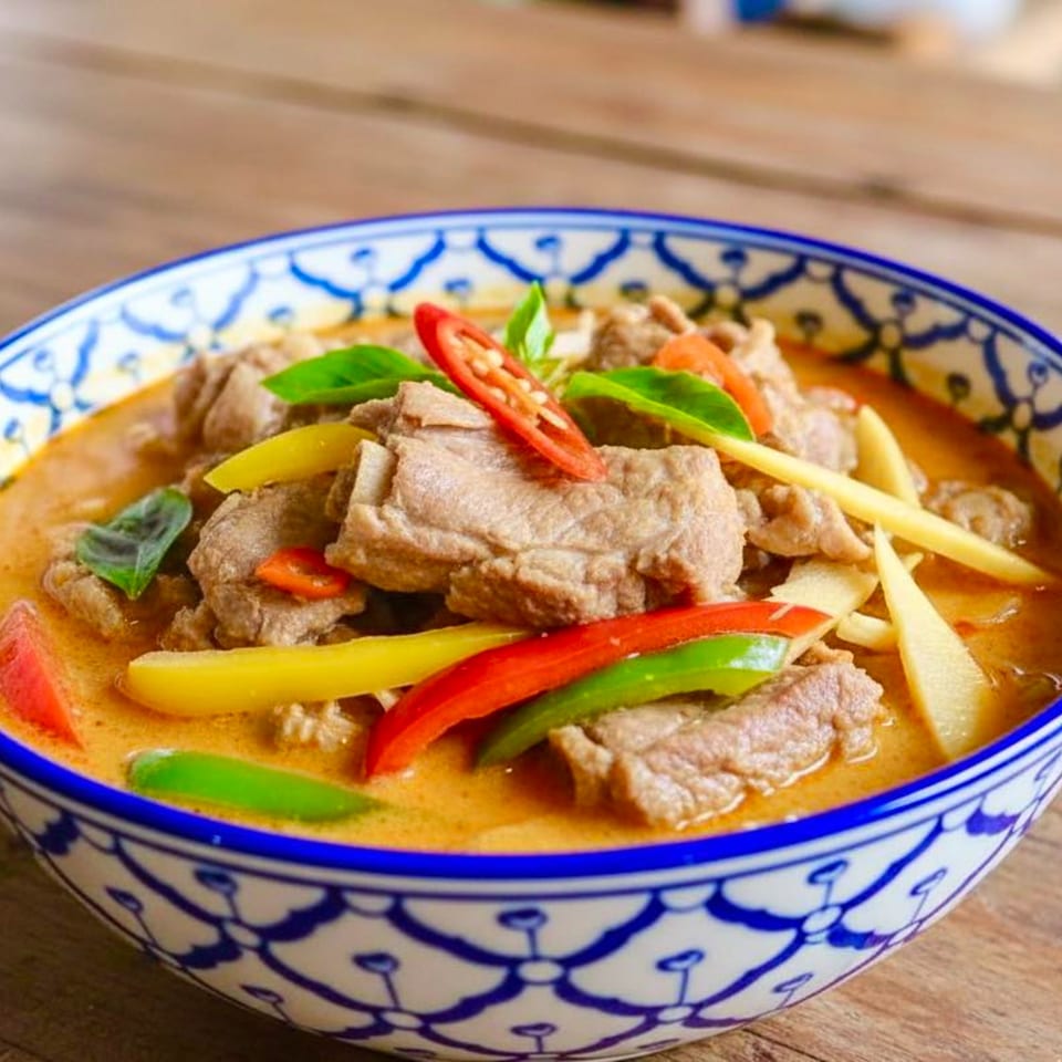 Thai Bangkok Bistro's red curry with beef, bell peppers, and basil in a decorative bowl.